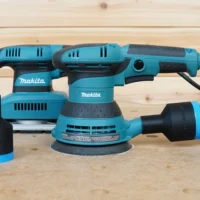 Black ToolCurve 1-7/8" hose adapter with blue band attached to a Makita 5in random orbit sander, plus a second adapter alongside