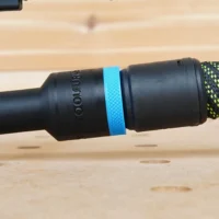ToolCurve hose adapter attached to a Makita 5-inch sander, with blue band marking and black braided hose connected to the right port