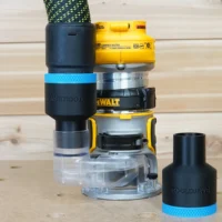 Black ToolCurve 36mm hose adapter with blue band joining a vacuum hose to a DeWalt compact router, plus a spare adapter