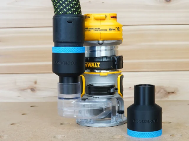 Black ToolCurve 36mm hose adapter with blue band joining a vacuum hose to a DeWalt compact router, plus a spare adapter