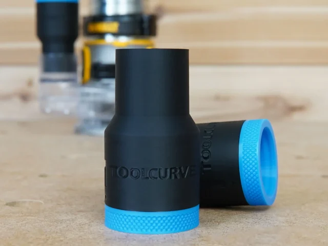 Black plastic hose adapter with blue knurled grip rings at each end, labeled ToolCurve, shown on wooden surface with tools in background