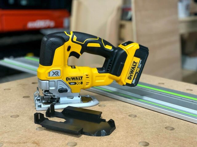 DeWalt 20V XR jig saw with black plastic rail adapter mounted to base, positioned next to Festool track on workbench