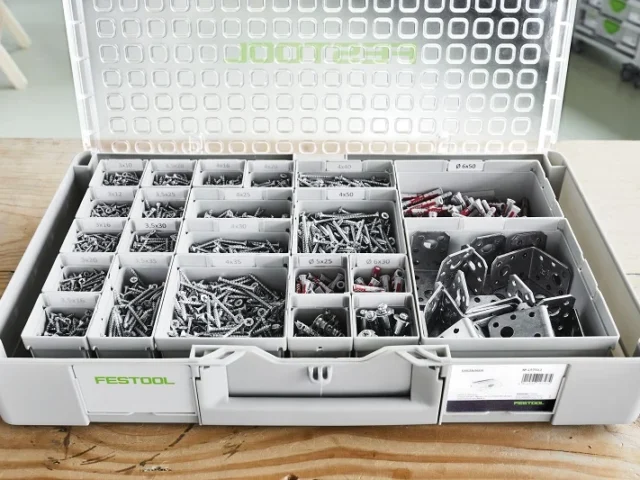 Festool Systainer storage box opened to reveal organized compartments filled with screws, fasteners, and hardware in various sizes