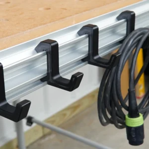 Four black utility hooks slid into the aluminum t-track edge of a Festool MFT table, one holding a coiled cord