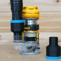 Black ToolCurve 1-7/8 inch hose adapter with blue band on a Dewalt DCW600 trim router, second adapter beside it