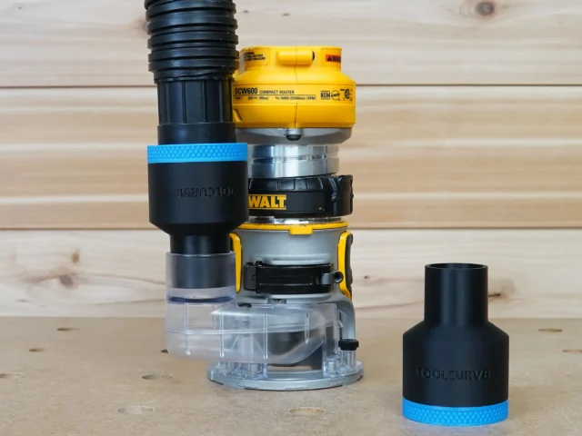 Black ToolCurve 1-7/8 inch hose adapter with blue band on a Dewalt DCW600 trim router, second adapter beside it