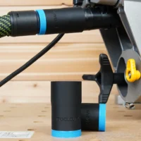 ToolCurve hose adapter mounted on Dewalt miter saw dust port with green braided hose attached, blue band identifying 27mm size