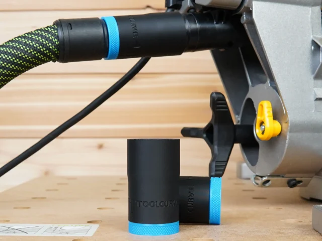 ToolCurve hose adapter mounted on Dewalt miter saw dust port with green braided hose attached, blue band identifying 27mm size