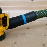 Black hose adapter with blue band attached to yellow Dewalt sander, connected to green and black braided hose