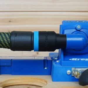Black ToolCurve hose adapter with blue band joining a green-flecked vacuum hose to a blue Kreg K5 jig dust port