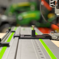 Bosch 1617 plunge router adapter mounted on Festool track rails with LR 32 plate, spring-loaded knob, and guide stops installed