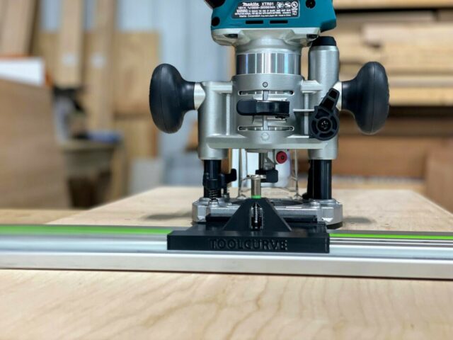 Makita plunge router mounted on ToolCurve LR32 plate attached to Festool guide rail, front view showing black adapter base and adjustment knobs