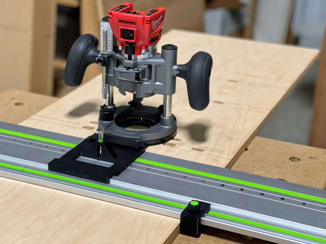 Milwaukee plunge router mounted on black ToolCurve LR32 base adapter positioned on Festool aluminum track rail with green stripe, shown on wooden workbench