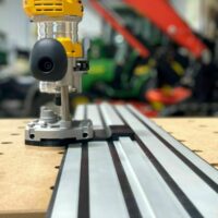 Dewalt plunge router adapter mounted on a Dewalt track saw rail, showing the router base attached to the aluminum track