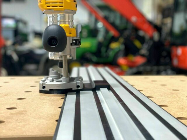 Dewalt plunge router adapter mounted on a Dewalt track saw rail, showing the router base attached to the aluminum track