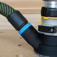 Black hose adapter with blue band attached to Dewalt trim router, connected to green and black fabric hose