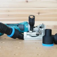 Black ToolCurve 1-7/8 inch hose adapter with blue ring on a Makita plate joiner, two spare adapters beside it