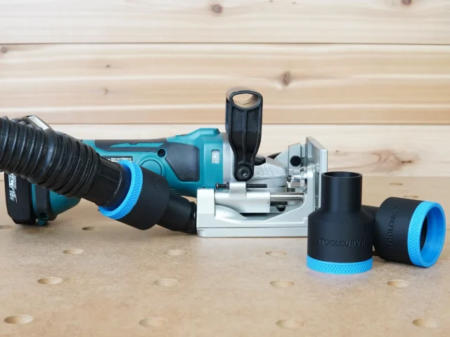 Black ToolCurve 1-7/8 inch hose adapter with blue ring on a Makita plate joiner, two spare adapters beside it