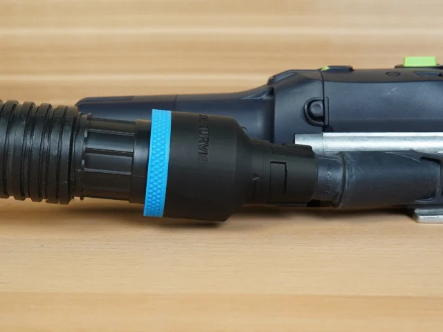 Black plastic hose adapter with blue band, attached to Festool sanding tool with ribbed hose connection on left side