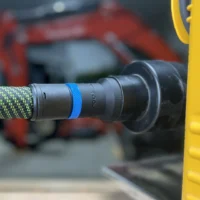 Black hose adapter with blue band attached to green and black Festool hose, connected to Dewalt 734 planer dust port