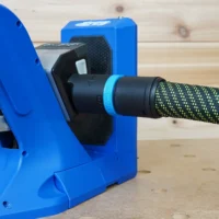 Blue hose adapter attached to Kreg 720 pocket-hole jig with black dust collection port and bright green braided hose connected