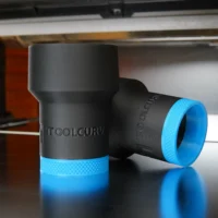 Black hose adapter with blue grip band, ToolCurve branding visible, shown as two units on a work surface