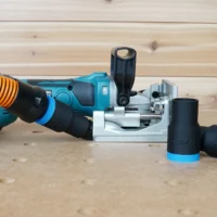 Black 1-1/4" hose adapter with blue collar on a Makita plate joiner, orange hose attached, spare adapters beside