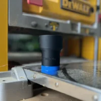Black ToolCurve hose adapter with blue band, mounted on a Dewalt 734 planer dust port