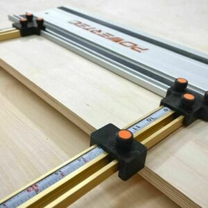 Black parallel guide brackets with orange knurled screws mounted on a PowerTec track saw rail and gold T-tracks