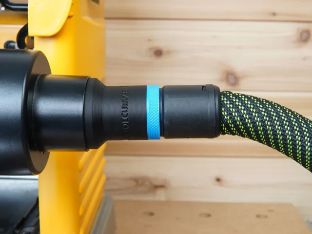Black hose adapter with blue band attached to Dewalt 734 planer, connected to green and black braided Festool hose