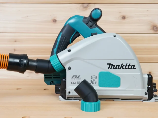 ToolCurve No-Snag Dust Port Adapter installed on a Makita track saw, angling the orange and black vacuum hose upward away from the cutting area