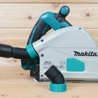 ToolCurve No-Snag dust port adapter installed on a Makita track saw, angling the vacuum hose upward away from the cutting area