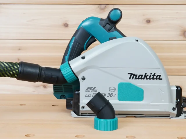 ToolCurve No-Snag dust port adapter installed on a Makita track saw, angling the vacuum hose upward away from the cutting area