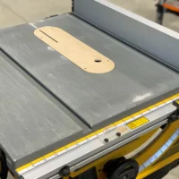 Wooden zero clearance insert with offset screw holes installed on Dewalt table saw blade throat
