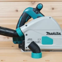 ToolCurve No-Snag Dust Port adapter attached to a Makita track saw, angling the black hose upward away from the cutting area