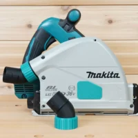 Black no-snag dust port with teal twist-lock collar installed on a Makita 36V track saw, side view
