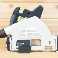Black arbor dust cover snapped onto the side of a Festool TSC 55 REB track saw, side view
