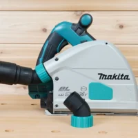 ToolCurve No-Snag Dust Port adapter installed on a Makita track saw, with hose attached showing upward-angled port design