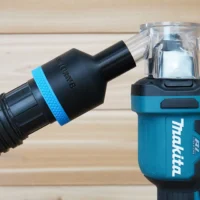 ToolCurve hose adapter with blue band attached to Makita drywall cut-out tool, connected to clear dust collection container