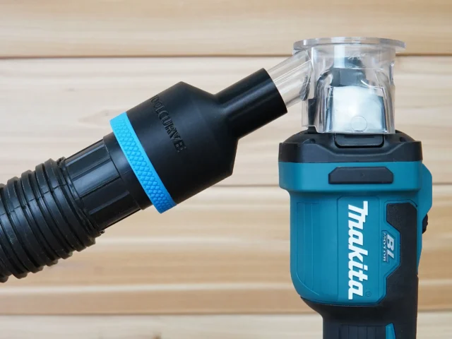 ToolCurve hose adapter with blue band attached to Makita drywall cut-out tool, connected to clear dust collection container