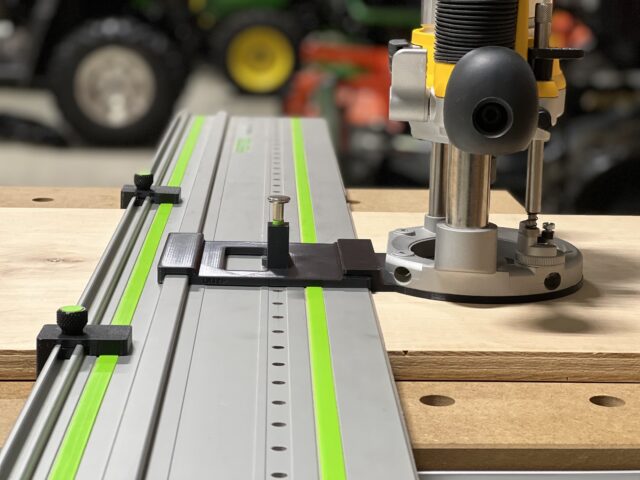 Dewalt DW618 router mounted on LR32 rail system with plunge base adapter and hole drilling jig installed on wooden workbench