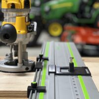 Dewalt DW618 router mounted on LR 32 rail with black adapter plate and spring-loaded positioning knob for hole drilling