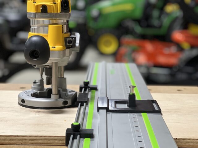 Dewalt DW618 router mounted on LR 32 rail with black adapter plate and spring-loaded positioning knob for hole drilling