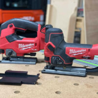 Milwaukee M18 jig saw adapter plates in black, displayed next to two Milwaukee jig saws on a workbench with guide rails
