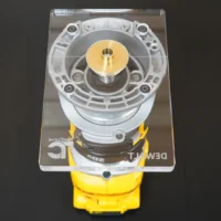 Clear 6x4 extended base plate on a Dewalt trim router, top view showing brass center bushing, four screws, etched logos