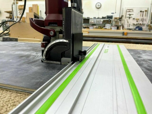 ZetaRail connector mounted on Festool guide rail with green edge straps, positioned on Lamello Zeta domino jointer in workshop