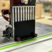ZetaRail adapter mounted on a Festool guide rail, showing slotted connection and red knurled adjustment knobs