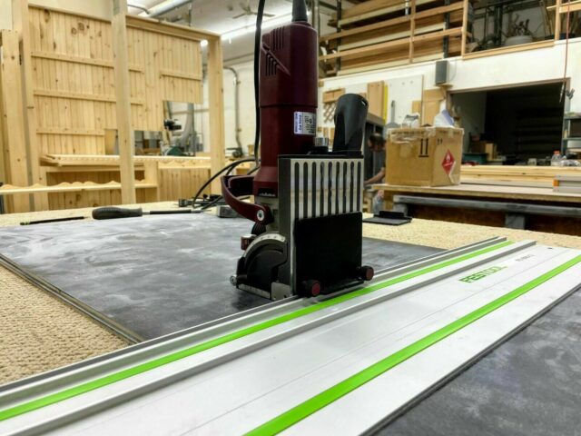 ZetaRail connector mounted on Lamello Zeta biscuit jointer, positioned on Festool guide rail with green stripe in woodworking shop