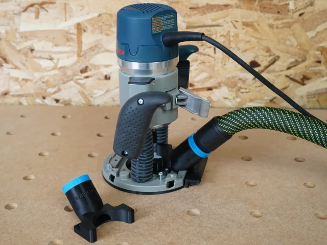 Hose adapter for Bosch 1617 plunge router mounted on blue Bosch router base with green Festool hose attached and adapter end piece shown separately