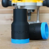 Black plastic hose adapter with blue grip rings at each end, labeled ToolCurve, shown on wooden workbench with Dewalt router in background